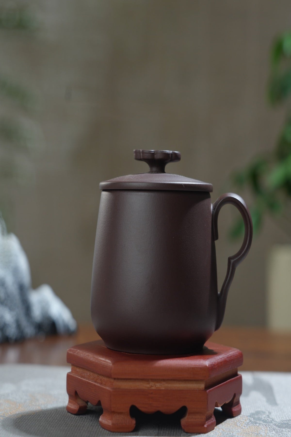 Xiaohuxianer Good Fortune Zisha Cup displayed on a wooden stand