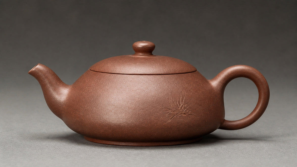 Three-quarter view of a Yixing zisha teapot showing its form, lid fit, spout, handle, and surface.