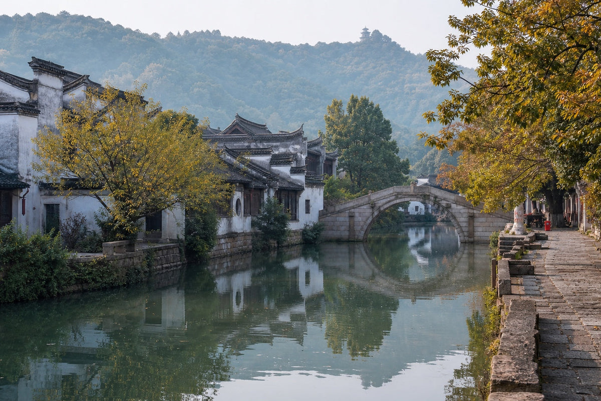 Traditional white-walled houses and a stone arch bridge reflected in the river at Huishan Ancient Town, Wuxi